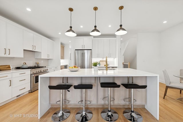 3300 S Giles Ave, Chicago, IL 60616 - kitchen featuring appliances with stainless steel finishes, decorative backsplash, a large island, light wood finished floors, and recessed lighting