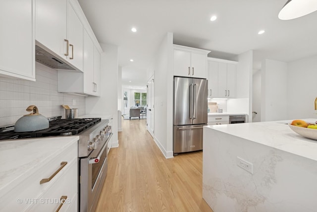 3300 S Giles Ave, Chicago, IL 60616 - kitchen with premium appliances, light wood finished floors, under cabinet range hood, white cabinetry, and recessed lighting