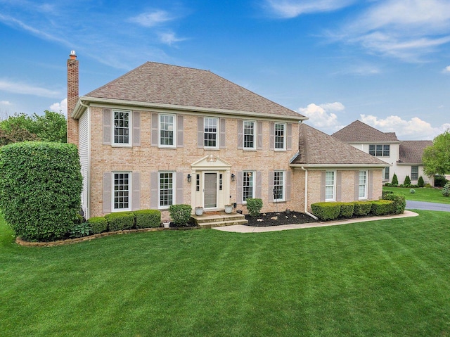 1560 Kensington Dr, Algonquin, IL 60102 - colonial inspired home with a chimney, a front yard, brick siding, and roof with shingles