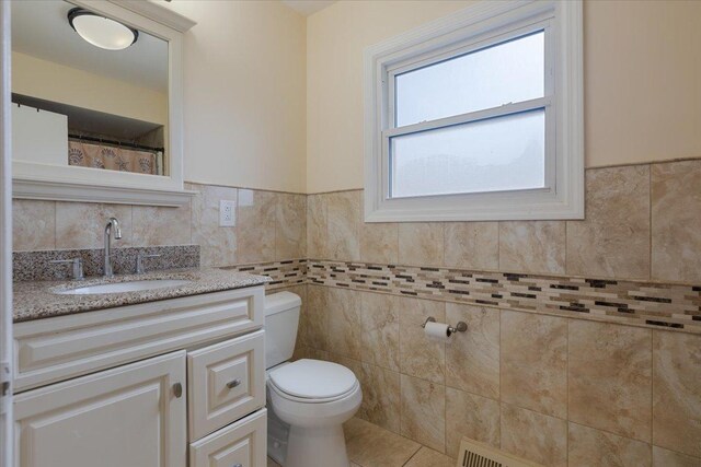 8353 N Drake Ave, Skokie, IL 60076 - full bath with vanity, toilet, tile walls, tile patterned floors, and a wainscoted wall
