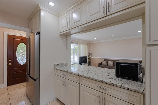 8353 N Drake Ave, Skokie, IL 60076 - kitchen featuring freestanding refrigerator, black microwave, light stone countertops, white cabinetry, and crown molding