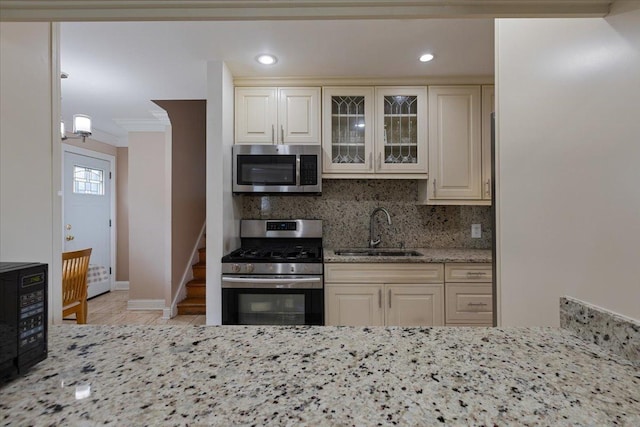 8353 N Drake Ave, Skokie, IL 60076 - kitchen featuring stainless steel appliances, a sink, light stone countertops, crown molding, and decorative backsplash