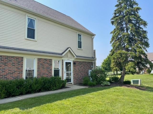 304 University Ln Unit 5, Elk Grove Village, IL 60007 - view of side of property featuring brick siding and a yard