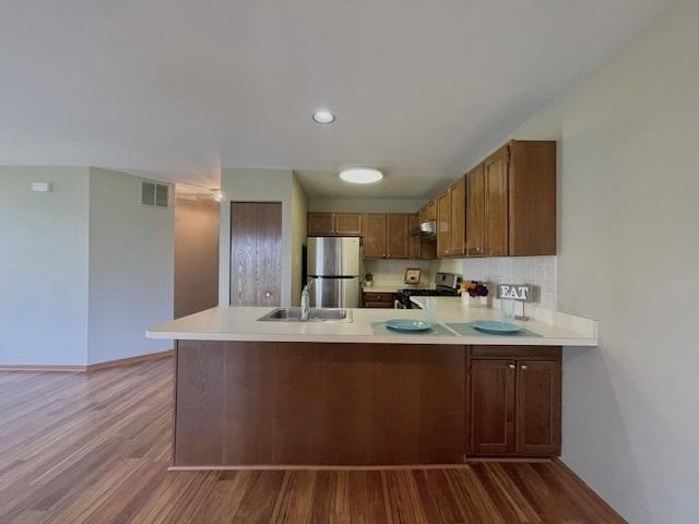 304 University Ln Unit 5, Elk Grove Village, IL 60007 - kitchen featuring freestanding refrigerator, stove, a peninsula, ventilation hood, and a ceiling fan