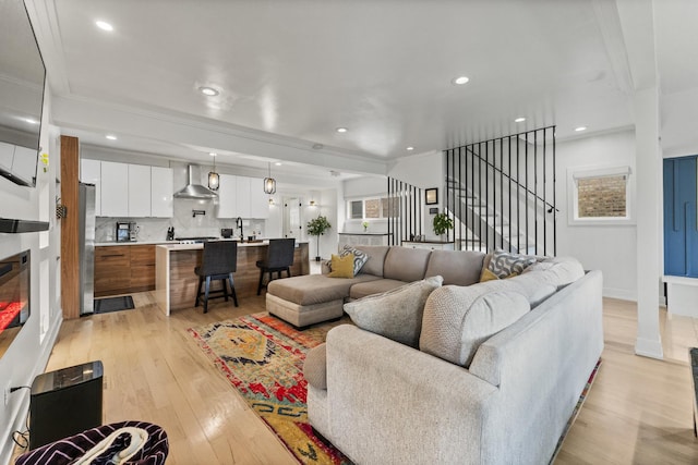 2705 Cuyler Ave, Berwyn, IL 60402 - living room featuring light wood-style flooring, stairway, crown molding, recessed lighting, and a glass covered fireplace