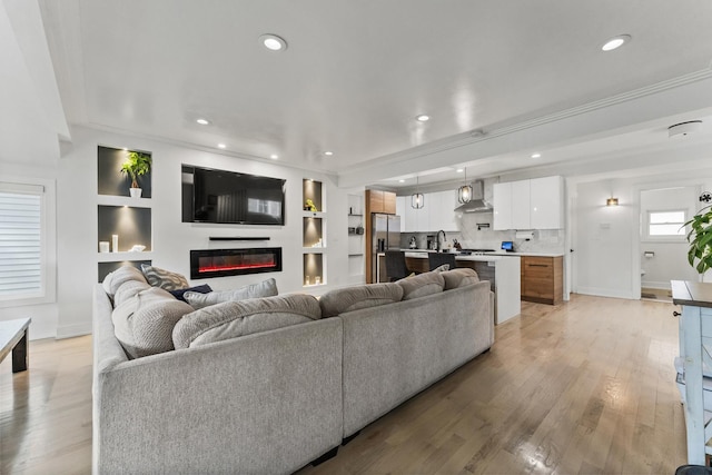 2705 Cuyler Ave, Berwyn, IL 60402 - living room with recessed lighting, a glass covered fireplace, light wood-style flooring, crown molding, and built in shelves