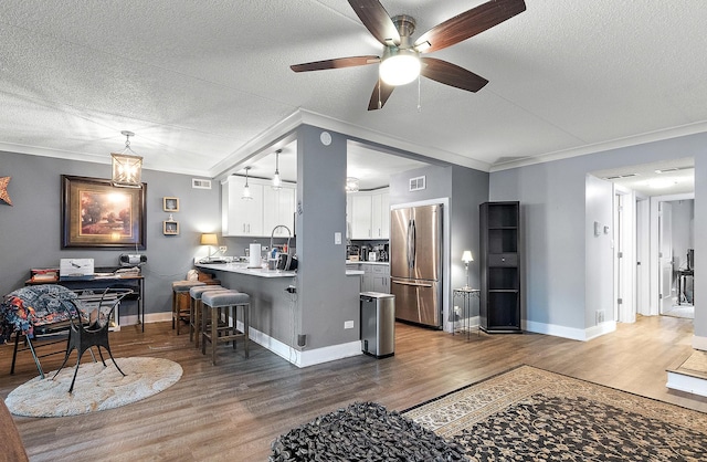 15713 Orlan Brook Dr Unit 97, Orland Park, IL 60462 - living area with wood finished floors, ceiling fan, ornamental molding, and a textured ceiling