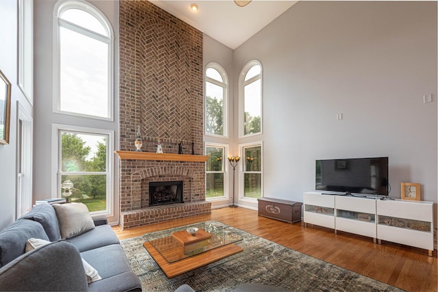 647 Oak Ln, South Elgin, IL 60177 - living room with high vaulted ceiling, wood finished floors, plenty of natural light, and a brick fireplace