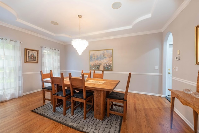 647 Oak Ln, South Elgin, IL 60177 - dining area with a tray ceiling, wood finished floors, a chandelier, arched walkways, and crown molding