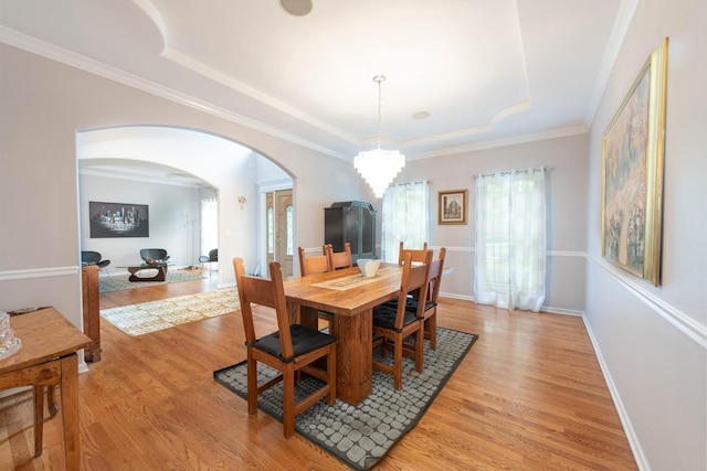 647 Oak Ln, South Elgin, IL 60177 - dining area featuring a raised ceiling, arched walkways, light wood finished floors, a chandelier, and crown molding