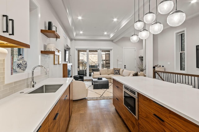 1304 N Hoyne Ave Unit 1, Chicago, IL 60622 - kitchen featuring brown cabinets, stainless steel microwave, a sink, modern cabinets, and light countertops