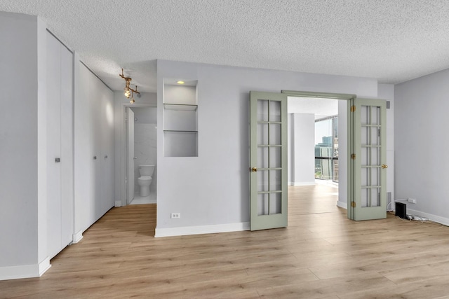 1122 N Clark St Unit 1710, Chicago, IL 60610 - unfurnished room featuring light wood-type flooring, french doors, a textured ceiling, and baseboards