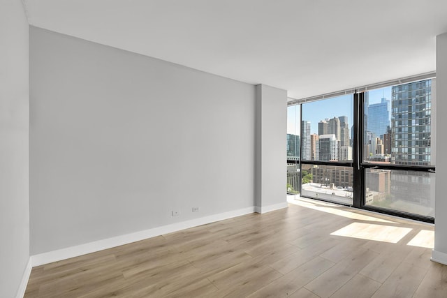 1122 N Clark St Unit 1710, Chicago, IL 60610 - spare room featuring wood finished floors, plenty of natural light, a view of skyline, and a wall of windows