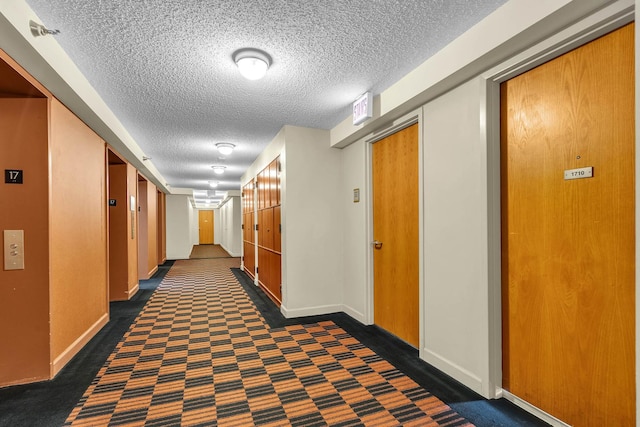 1122 N Clark St Unit 1710, Chicago, IL 60610 - corridor with a textured ceiling, baseboards, and dark carpet