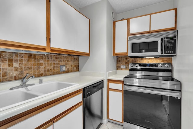 1122 N Clark St Unit 1710, Chicago, IL 60610 - kitchen with stainless steel appliances, white cabinetry, backsplash, light countertops, and a sink