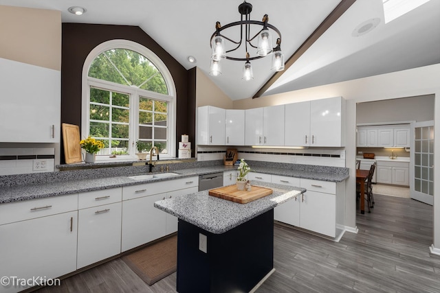 2609 Dougall Rd, Joliet, IL 60433 - kitchen with a sink, stainless steel dishwasher, vaulted ceiling, backsplash, and white cabinets