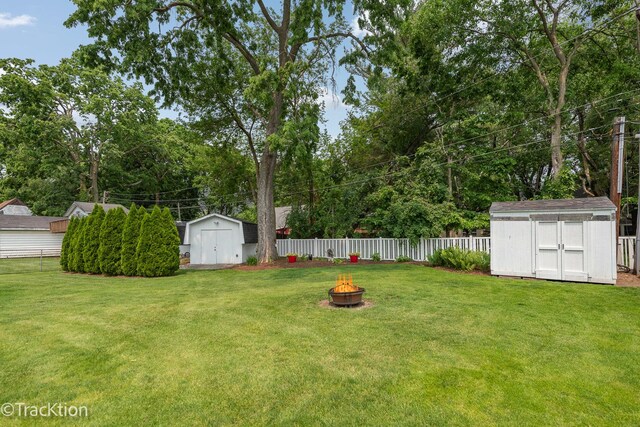 2609 Dougall Rd, Joliet, IL 60433 - fenced backyard featuring a shed, an outdoor fire pit, and view of wooded area