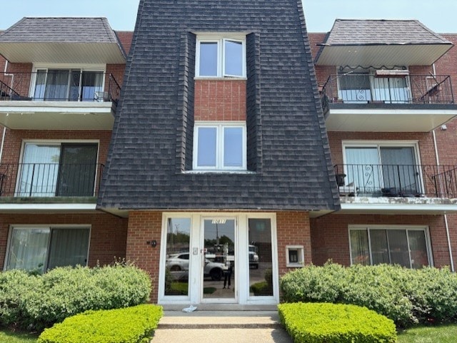 10811 S Keating Ave Unit 3Se, Oak Lawn, IL 60453 - view of exterior entry with a balcony, brick siding, a shingled roof, and french doors