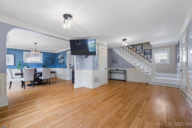 721 S Batavia Ave, Batavia, IL 60510 - living room with a chandelier, light wood-type flooring, stairway, a decorative wall, and ornamental molding