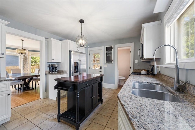 721 S Batavia Ave, Batavia, IL 60510 - kitchen with stainless steel refrigerator with ice dispenser, a chandelier, white cabinets, and light tile patterned flooring