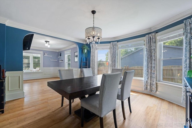 721 S Batavia Ave, Batavia, IL 60510 - dining space featuring arched walkways, a chandelier, a wainscoted wall, light wood-style flooring, and ornamental molding