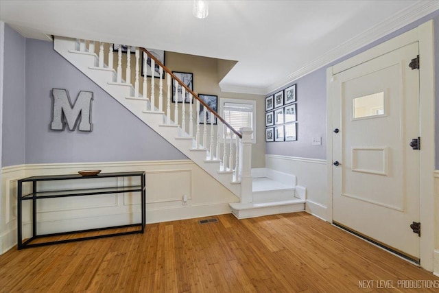 721 S Batavia Ave, Batavia, IL 60510 - foyer featuring stairs, wainscoting, wood finished floors, and ornamental molding