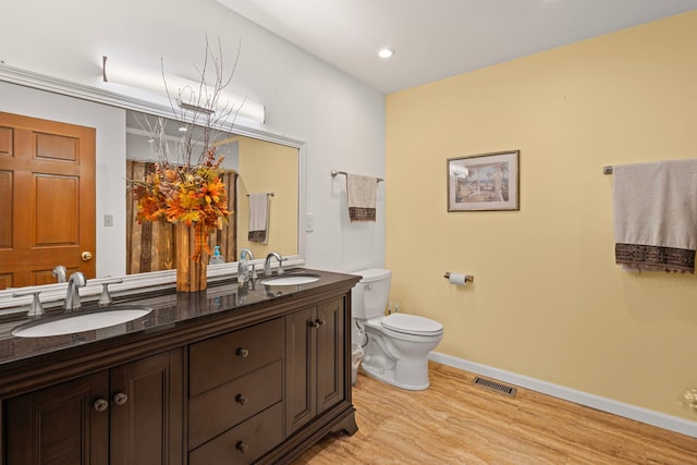 6897 Galena Rd, Bristol, IL 60512 - full bathroom with double vanity, toilet, wood finished floors, baseboards, and recessed lighting