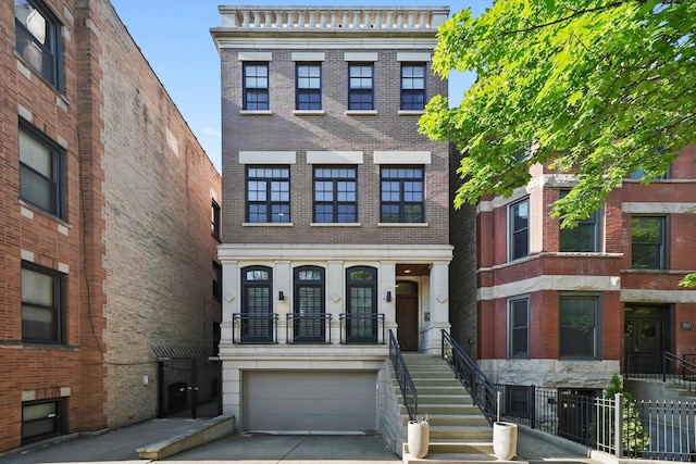 851 W Fletcher St Unit 2, Chicago, IL 60657 - view of property with an attached garage, brick siding, driveway, and stairway