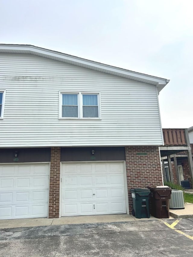 19510 116th Ave Unit D, Mokena, IL 60448 - view of property exterior featuring brick siding, an attached garage, and central air condition unit