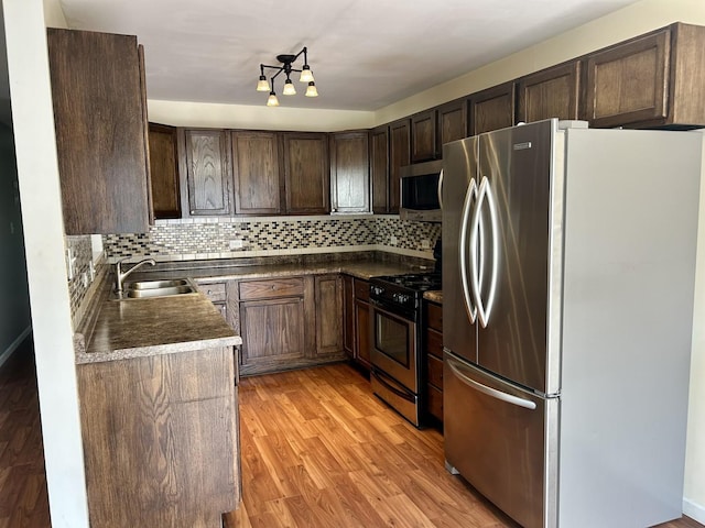19510 116th Ave Unit D, Mokena, IL 60448 - kitchen with appliances with stainless steel finishes, dark countertops, dark brown cabinetry, and tasteful backsplash