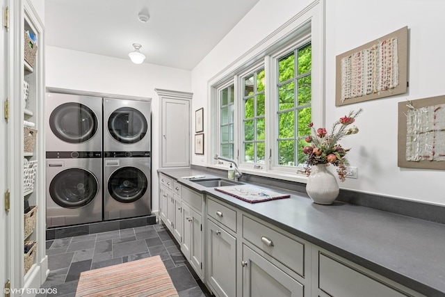 laundry area with stacked washer / dryer, cabinet space, healthy amount of natural light, and independent washer and dryer
