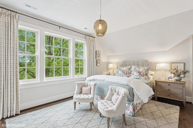 bedroom with wood finished floors, multiple windows, lofted ceiling, and baseboards