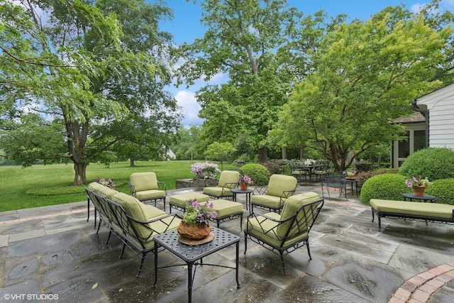 view of patio / terrace featuring an outdoor living space and view of wooded area