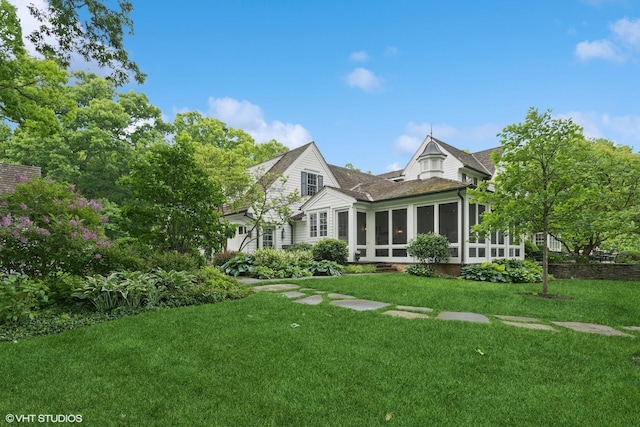 view of front of home featuring a sunroom and a front yard