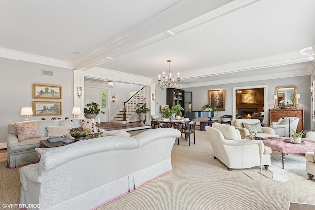 living room featuring stairs, ornamental molding, a chandelier, light carpet, and a lit fireplace