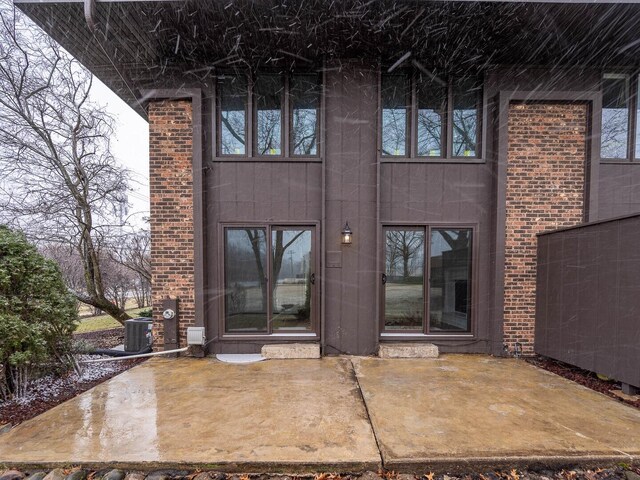 10 Cedar Creek Ct Unit A-10, Palos Heights, IL 60463 - doorway to property with a patio, central air condition unit, and brick siding
