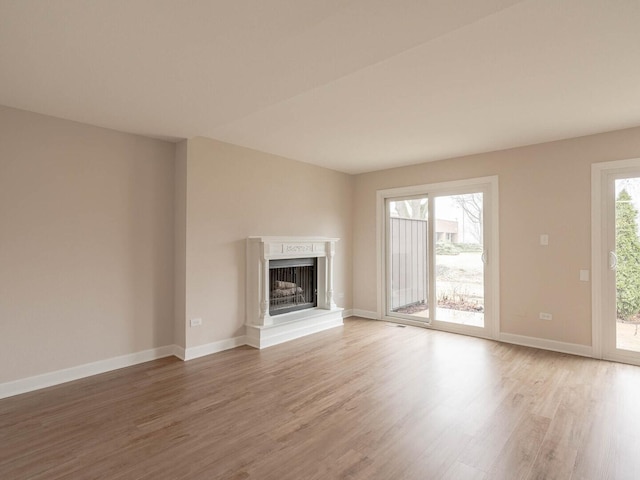 10 Cedar Creek Ct Unit A-10, Palos Heights, IL 60463 - unfurnished living room with light wood finished floors, a fireplace with raised hearth, and baseboards