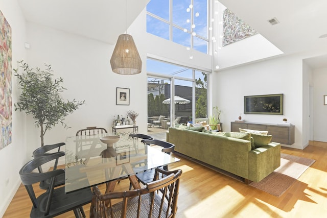 1615 N Wolcott Ave Unit 204, Chicago, IL 60622 - living room featuring light wood-style floors, baseboards, and a towering ceiling