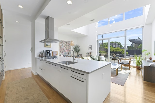 1615 N Wolcott Ave Unit 204, Chicago, IL 60622 - kitchen featuring a sink, island range hood, modern cabinets, white cabinets, and light wood-style flooring