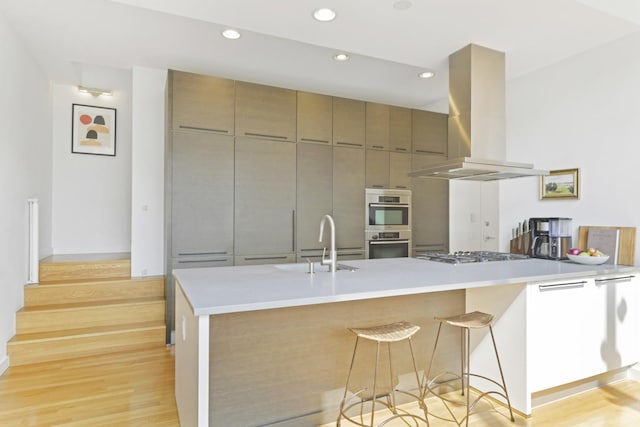 1615 N Wolcott Ave Unit 204, Chicago, IL 60622 - kitchen with island range hood, a sink, light wood-type flooring, appliances with stainless steel finishes, and recessed lighting