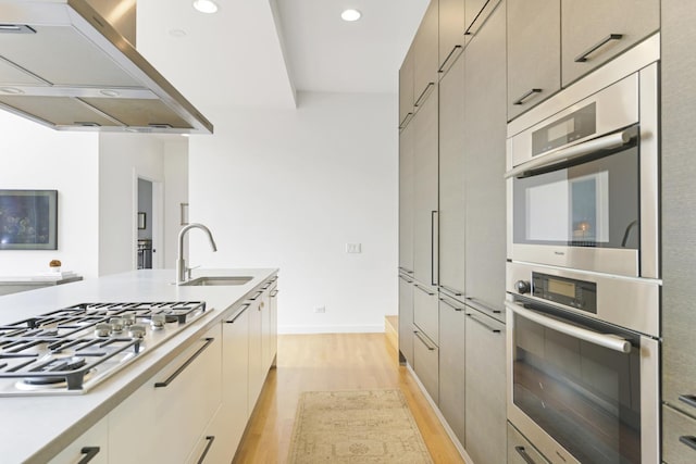 1615 N Wolcott Ave Unit 204, Chicago, IL 60622 - kitchen with a sink, custom range hood, stainless steel appliances, light wood-style flooring, and light countertops