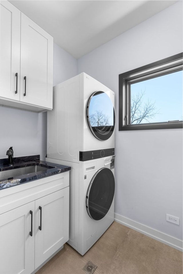 299 Cottage Ave, Glen Ellyn, IL 60137 - laundry area with stacked washer / drying machine, cabinet space, and baseboards