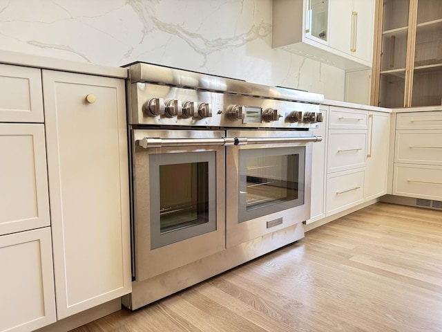 299 Cottage Ave, Glen Ellyn, IL 60137 - kitchen featuring double oven range, light wood-style floors, glass insert cabinets, and white cabinets