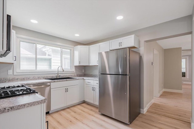 810 N Oak St, Bloomington, IL 61701 - kitchen featuring stainless steel appliances, a sink, light wood-style floors, white cabinets, and recessed lighting