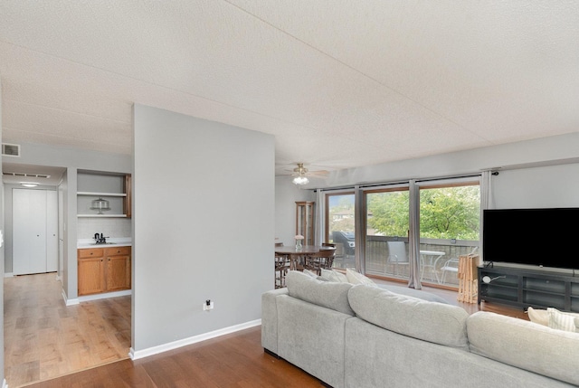 1068 Ashley Ct N Unit 2A, Lockport, IL 60441 - living area featuring light wood-style floors, ceiling fan, baseboards, and a textured ceiling