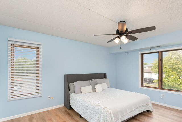 1068 Ashley Ct N Unit 2A, Lockport, IL 60441 - bedroom with wood finished floors, baseboards, a textured ceiling, and ceiling fan