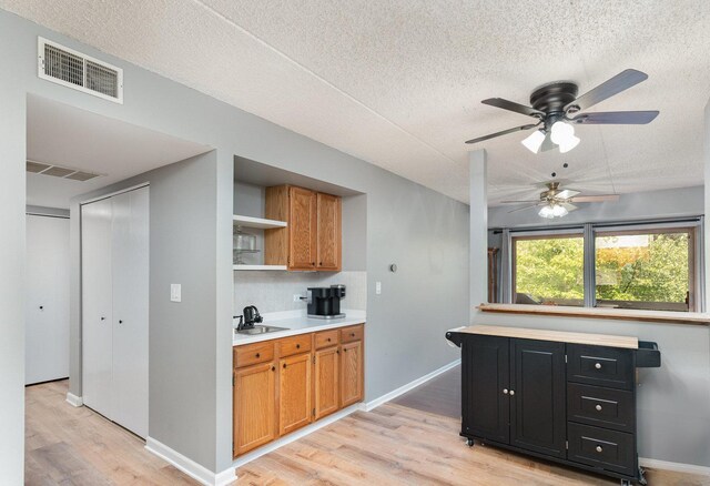 1068 Ashley Ct N Unit 2A, Lockport, IL 60441 - kitchen featuring a ceiling fan, light wood-type flooring, light countertops, open shelves, and a textured ceiling
