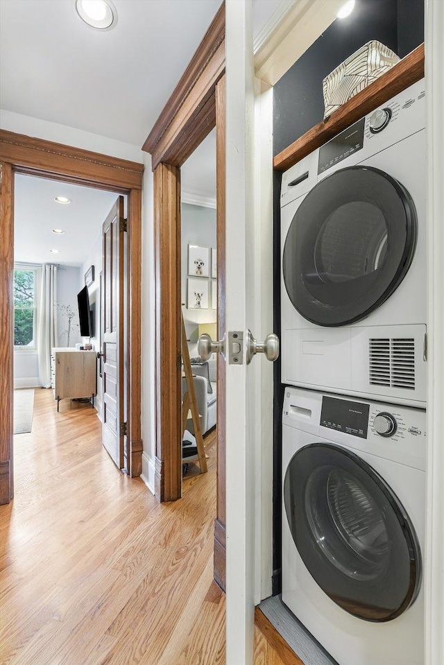 706 W Melrose Ave Unit 3, Chicago, IL 60657 - washroom with stacked washing machine and dryer, light wood finished floors, baseboards, recessed lighting, and ornamental molding