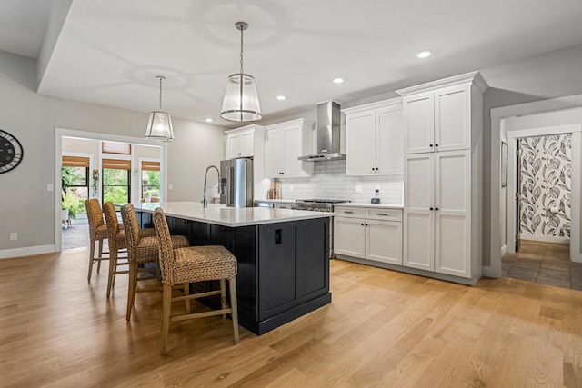 4203 Curtis Meadow Dr, Champaign, IL 61822 - kitchen featuring wall chimney exhaust hood, stainless steel fridge with ice dispenser, an island with sink, light wood-type flooring, and recessed lighting
