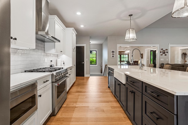 4203 Curtis Meadow Dr, Champaign, IL 61822 - kitchen featuring wall chimney exhaust hood, stainless steel appliances, white cabinets, light wood-type flooring, and decorative backsplash